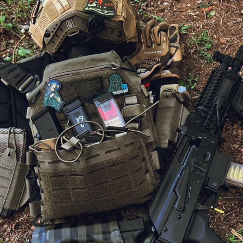 Invictus Pattern MK I Modular Plate Carrier with tactical gear and accessories laid on the ground.